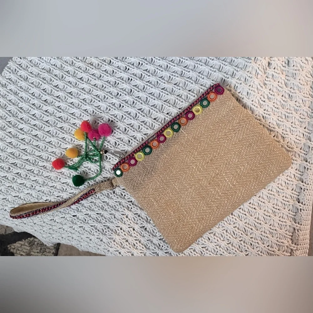 bohemian-style woven clutch jute with pom pom accents